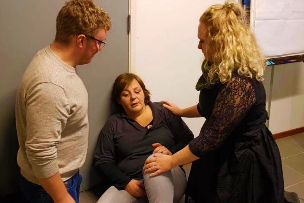 Twee leiders ontfermen zich over een flauwgevallen mede leiding tijdens de workshop.