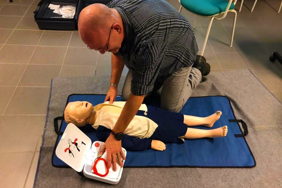 Een workshopleider laat zien hoe je een kind moet reanimeren met een pop.