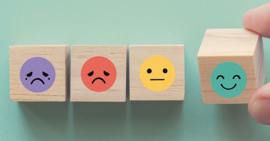 Vier houten blokken met verschillende emoties.