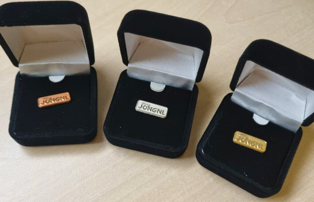 Een bronzen, zilveren en gouden waarderingsspeld.