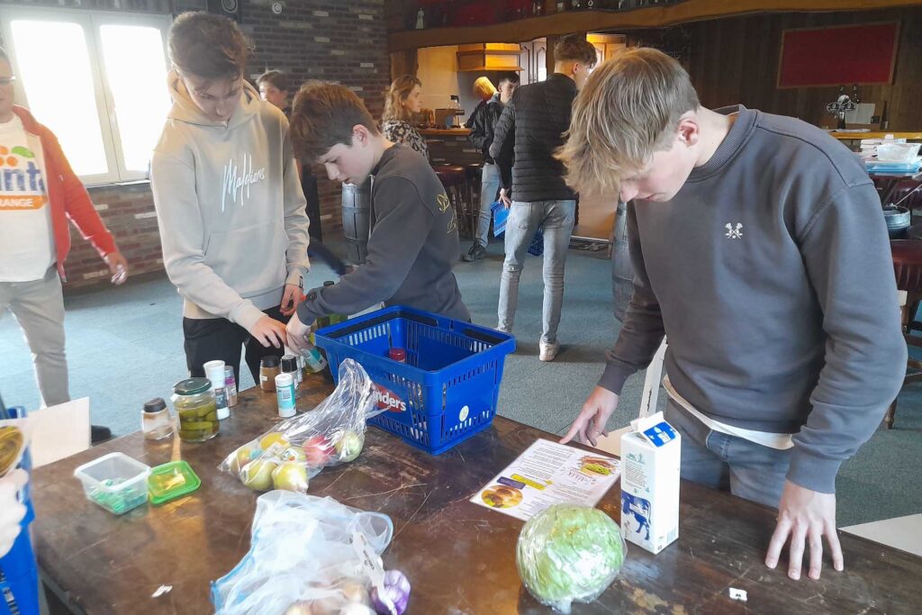 Jongeren lezen het recept voor het gerecht wat zij moeten maken.