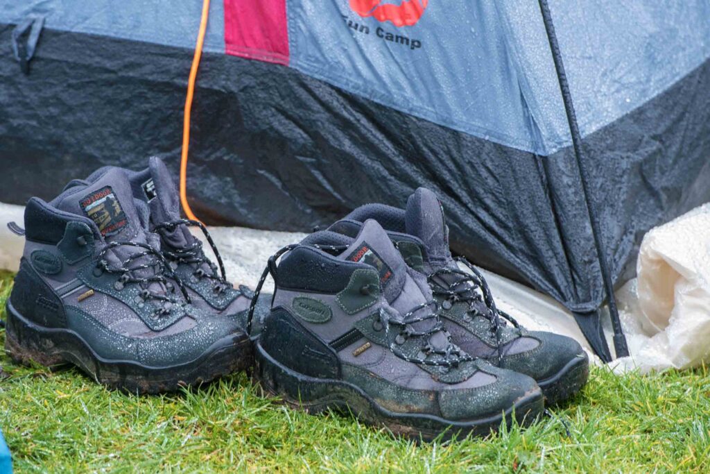 Wandelschoenen staan buiten een popup tentje.