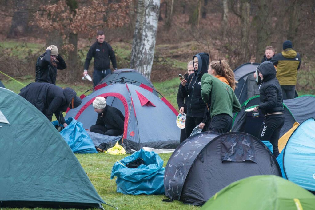 Kleine pop up tentjes staan verspreid over een veld.