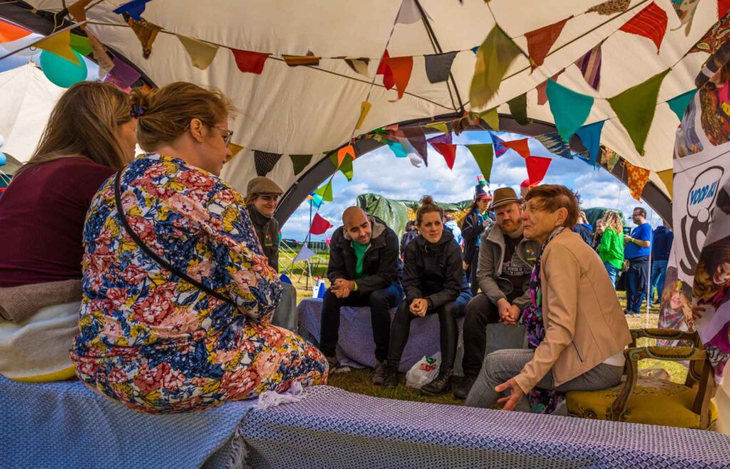 Een groep mensen verzamelt zich op een rustige plek tijdens het festival.