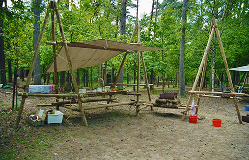 Een zelfgemaakte eethoek van sjorhout, touw en zeil.