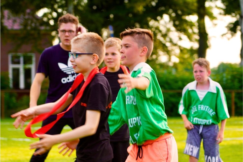 Een groep leden en hun leider spelen een balspel.