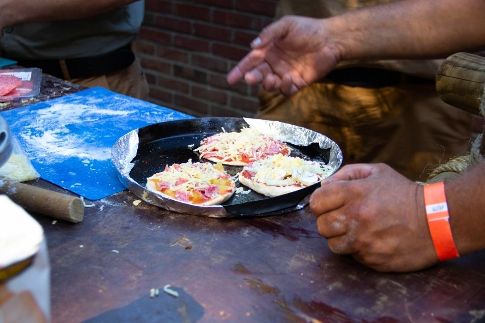 Een leider heeft pizza's gemaakt tijdens de outdoorcooking workshop.