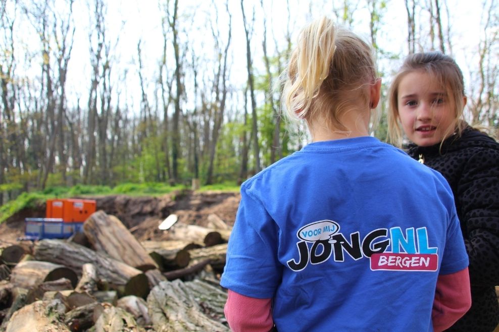 Twee meisjes staan te praten. Een meisje heeft een JongNL t-shirt aan.