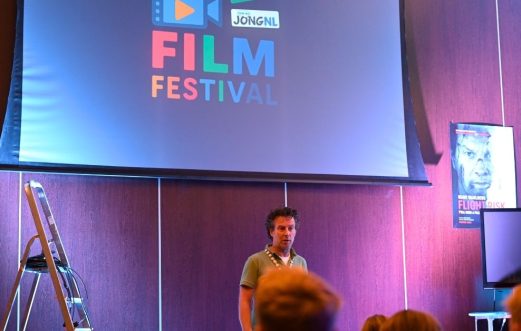 Een workshopleider staat voor een presentatiescherm tijdens een workshop sound design.